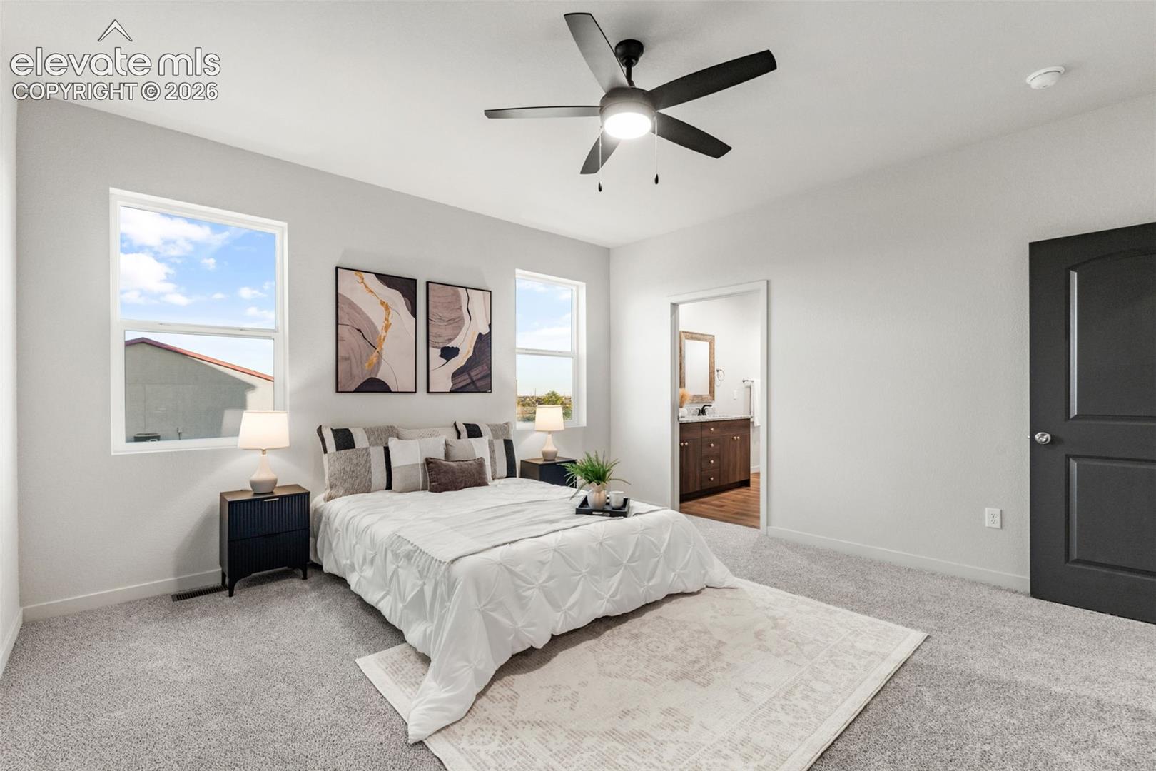 Neutral-toned bedroom featuring carpeting, a matte black multi-blade ceiling fan with integrated lighting, and a dark-toned interior door with metallic hardware