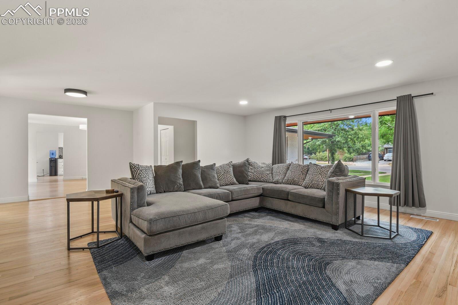 Bright living space featuring hardwood flooring and recessed lighting
