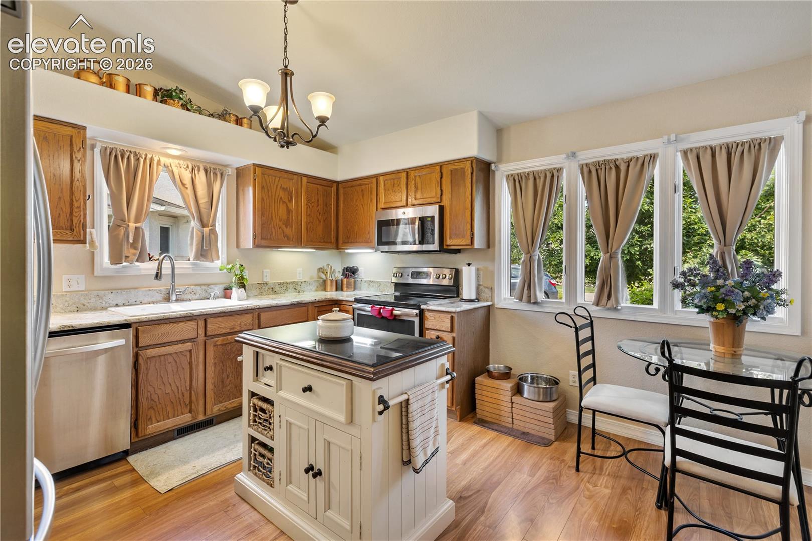 Spacious eat-in kitchen features solid granite countertops and stainless steel appliances.  The portable island is included!  