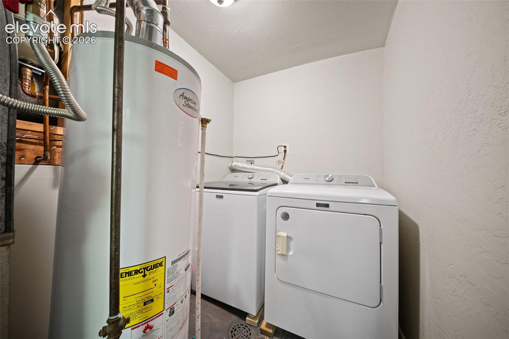 Utility room featuring a water heater, washing machine, and dryer