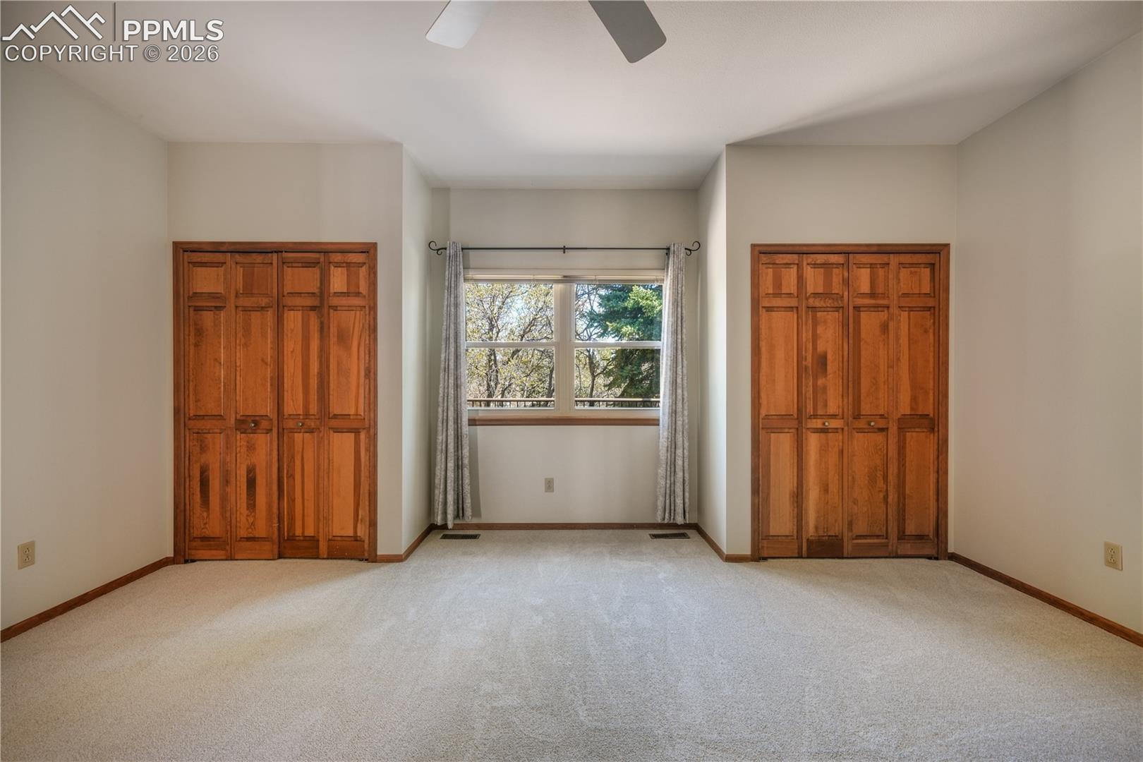 Main level primary bedroom with new carpet, ensuite 5 piece bathroom, walk in closets
