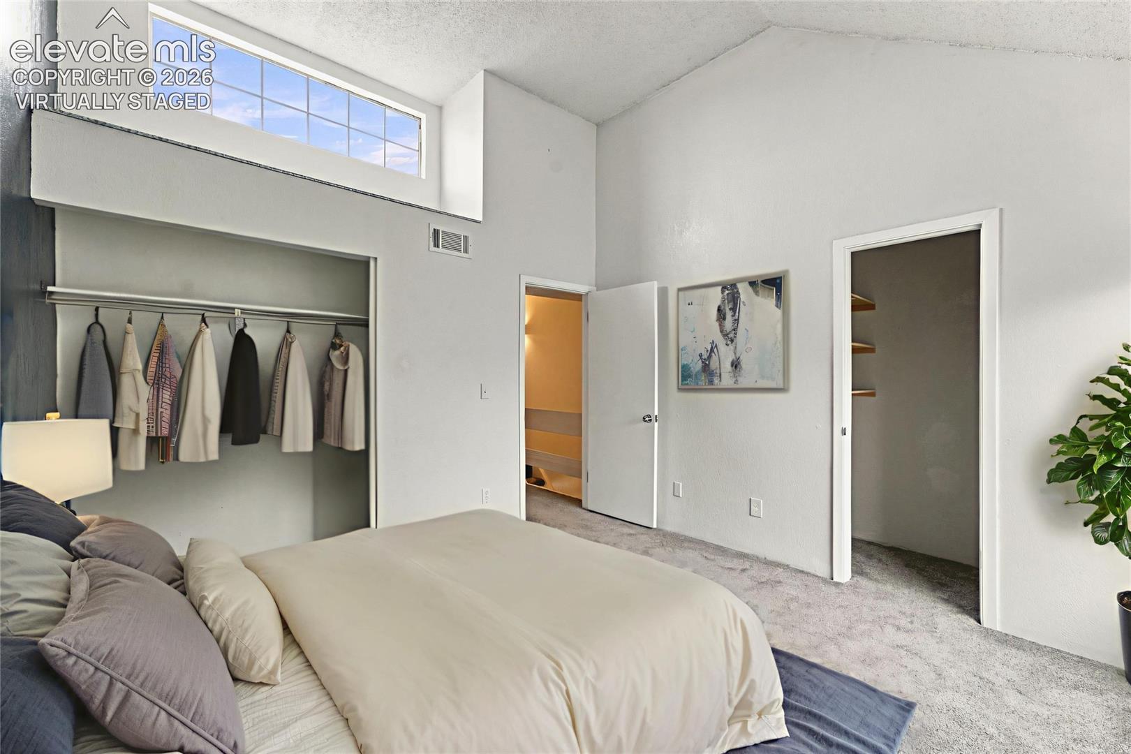 Vaulted ceilings featuring a transom window, wall-to-wall carpeting, and dual built-in storage closets
Virtually Staged