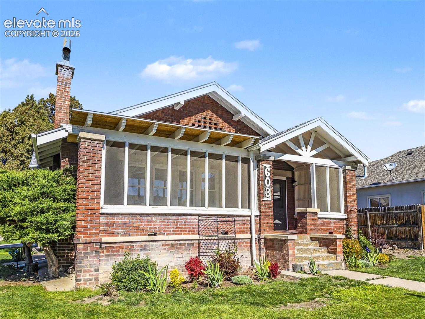 Brick exterior featuring a screened porch and covered entry with exposed rafter tails