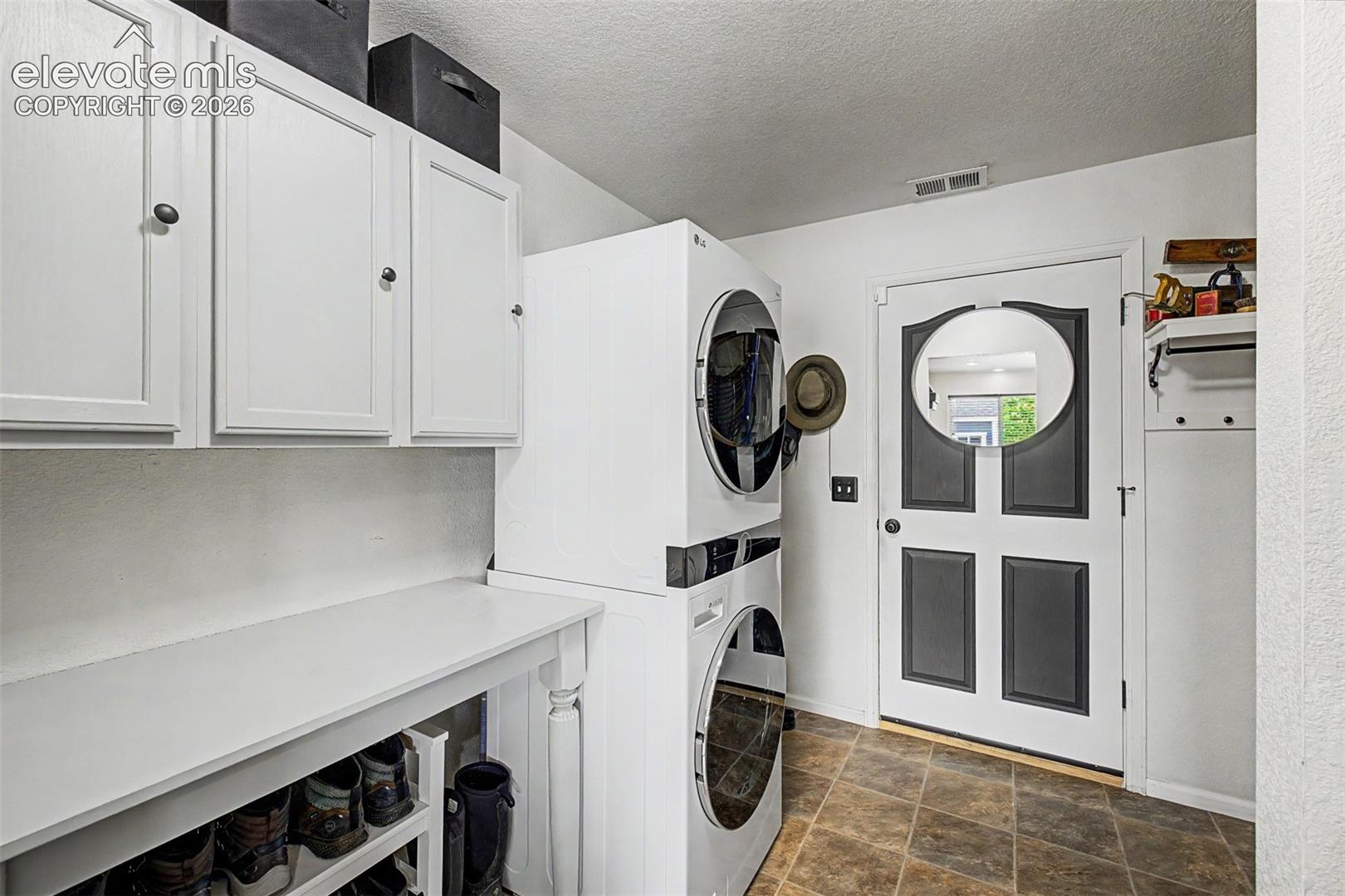 The dedicated laundry and mudroom is thoughtfully laid out with cabinetry, a folding surface, and a back entry that keeps the everyday chaos of coming and going completely contained.