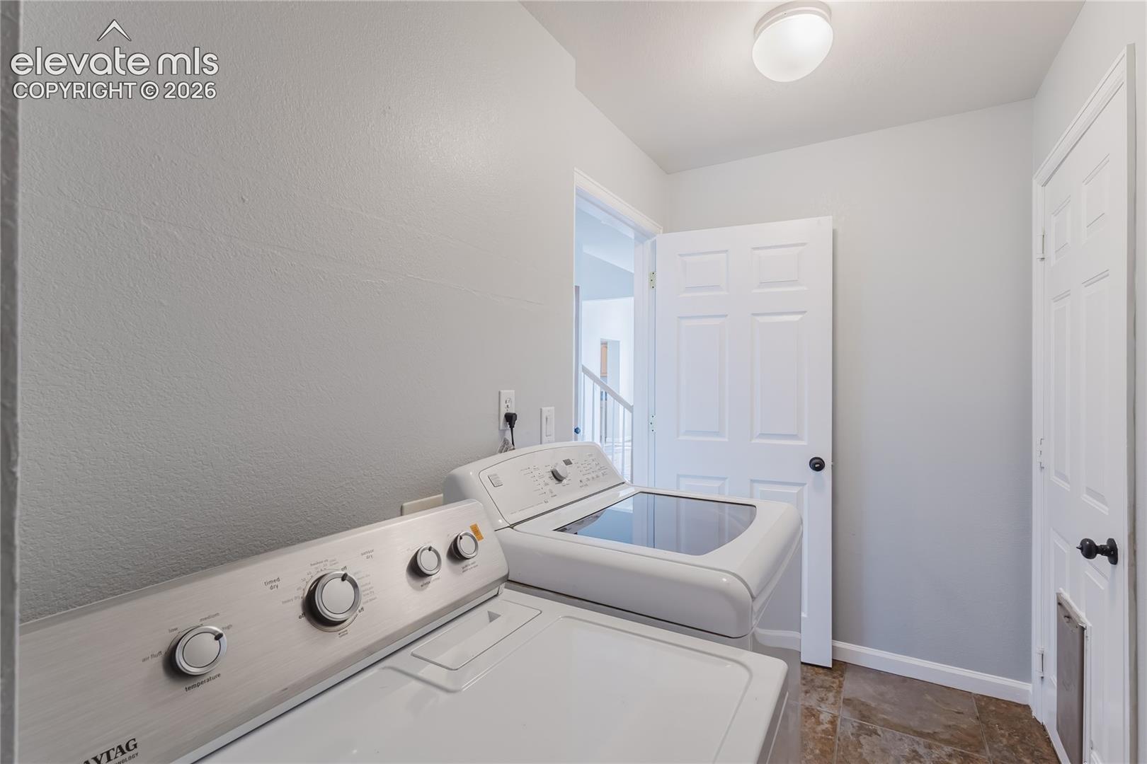 Utility area with tile flooring and a flush-mount ceiling light
