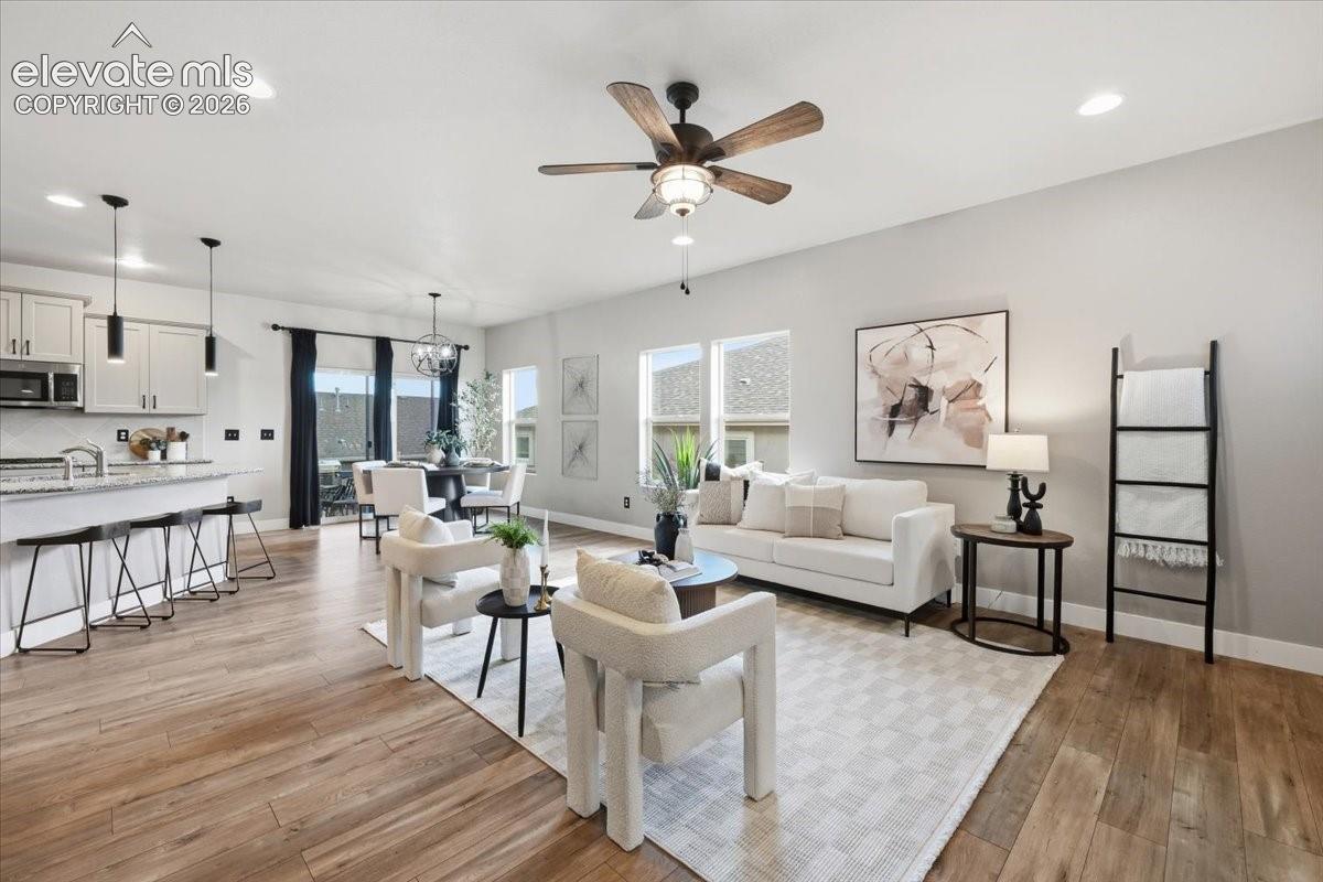 Open-concept living space featuring wood-finish flooring, recessed lighting, and a ceiling fan
