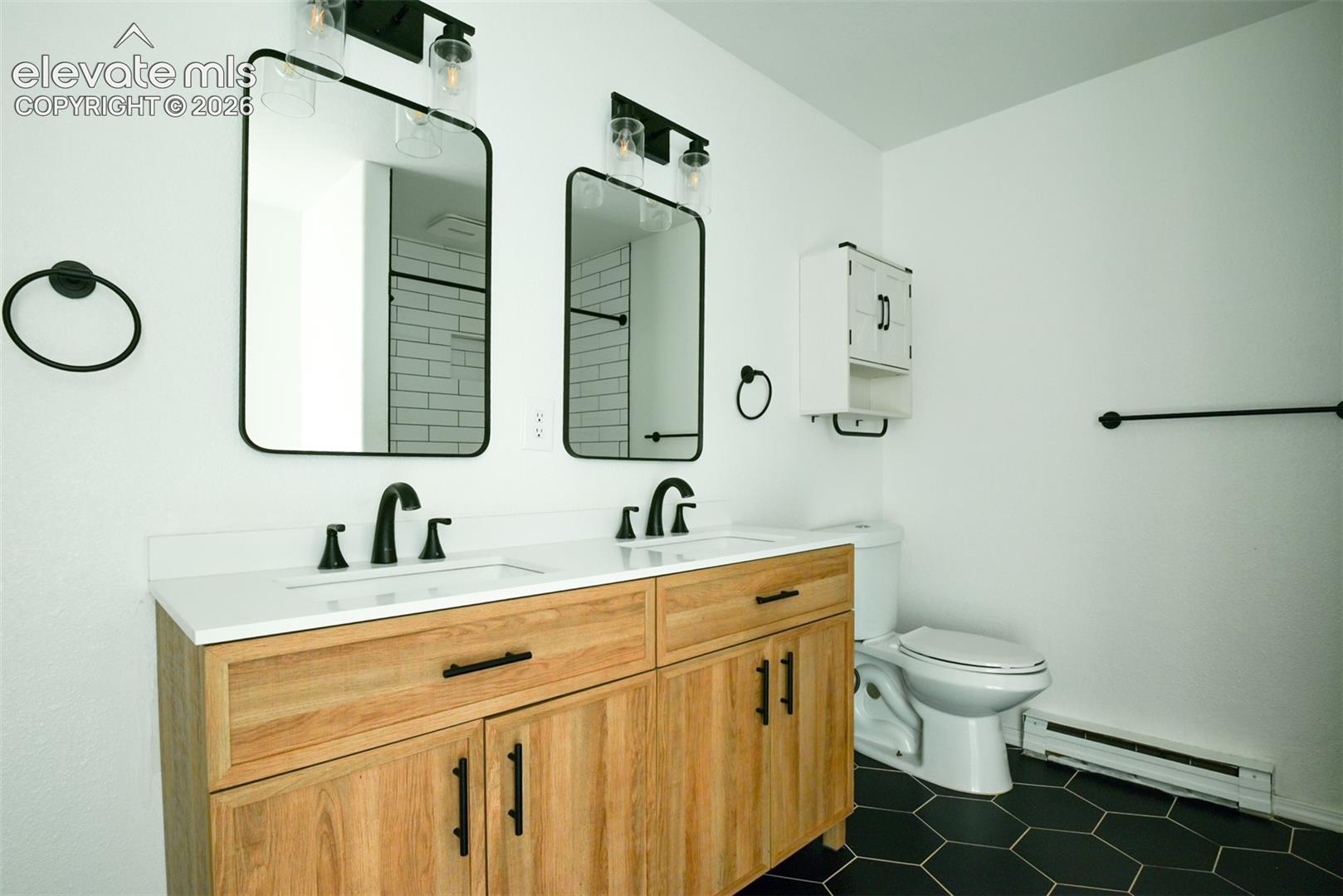 Dual vanity with wood-finish cabinetry and matte black hardware