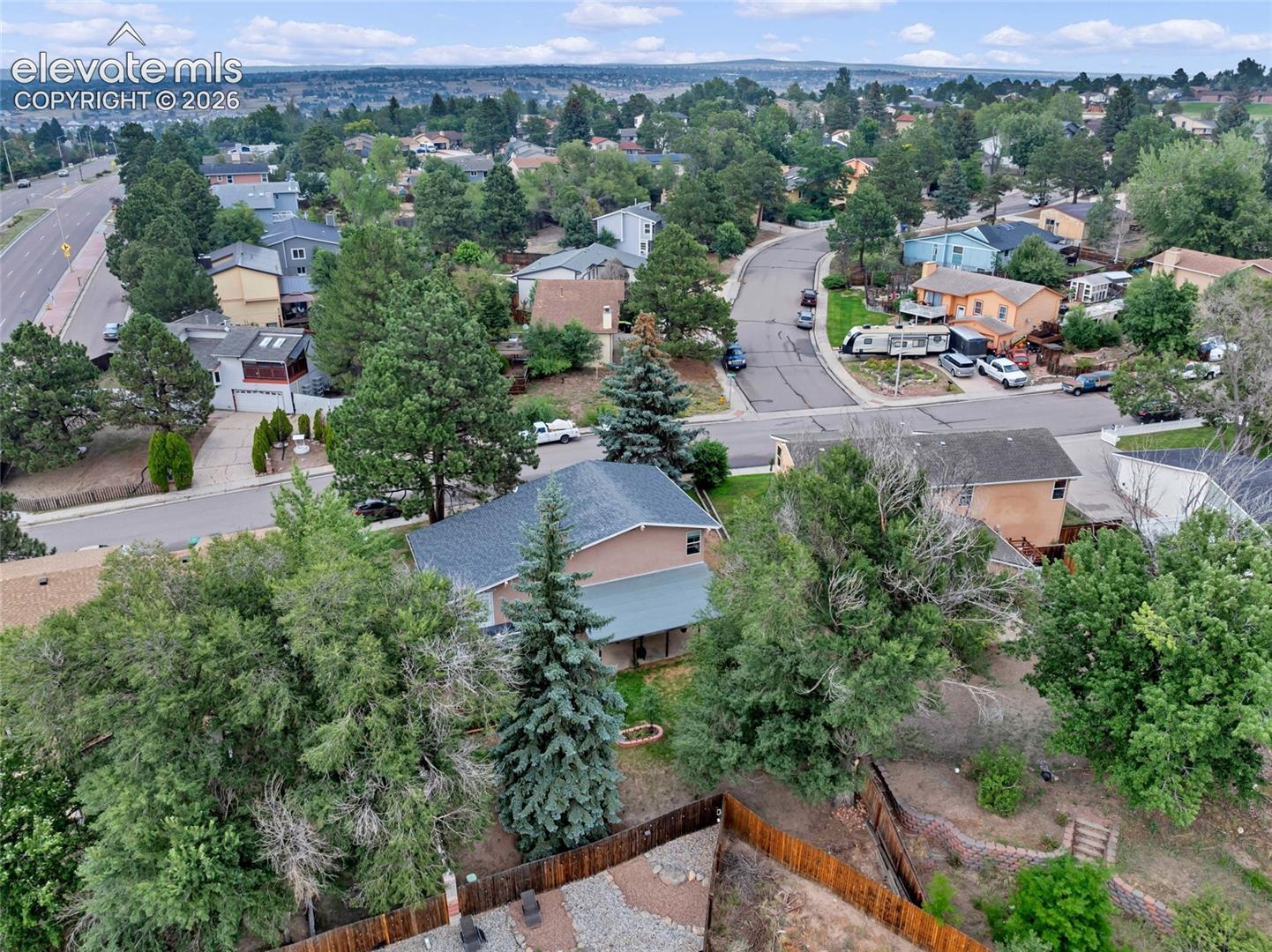 Spacious residential property with a multi-level rear yard, featuring a retaining wall system and mature trees