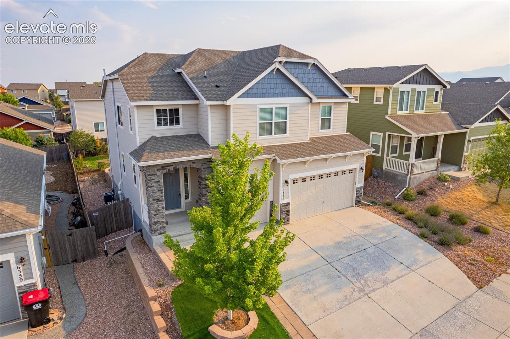 Two-story exterior with a covered entry, stone facade accents, and an attached two-car garage