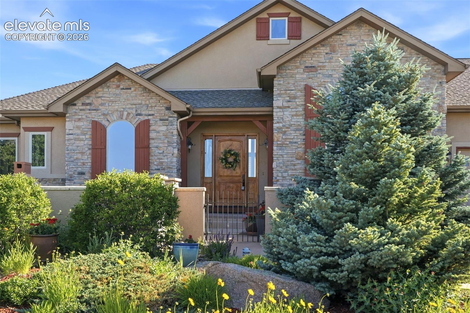 Stone and stucco exterior with arched window shutters