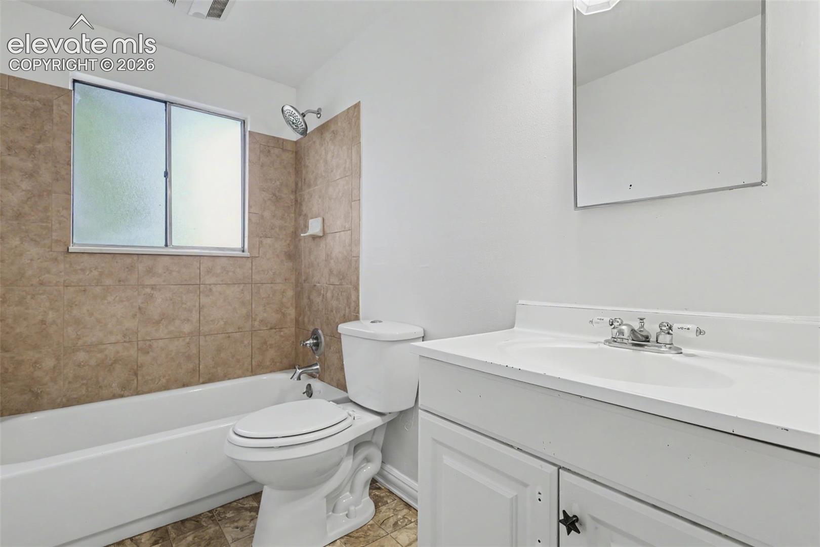 Full upper level bathroom with tiled tub surround.