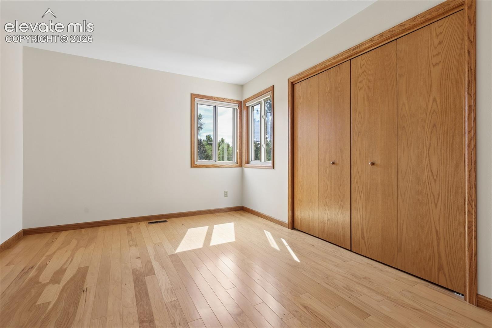3rd spacious bedroom with hardwood flooring closet with built-in shelving. Beautiful view from the corner window.