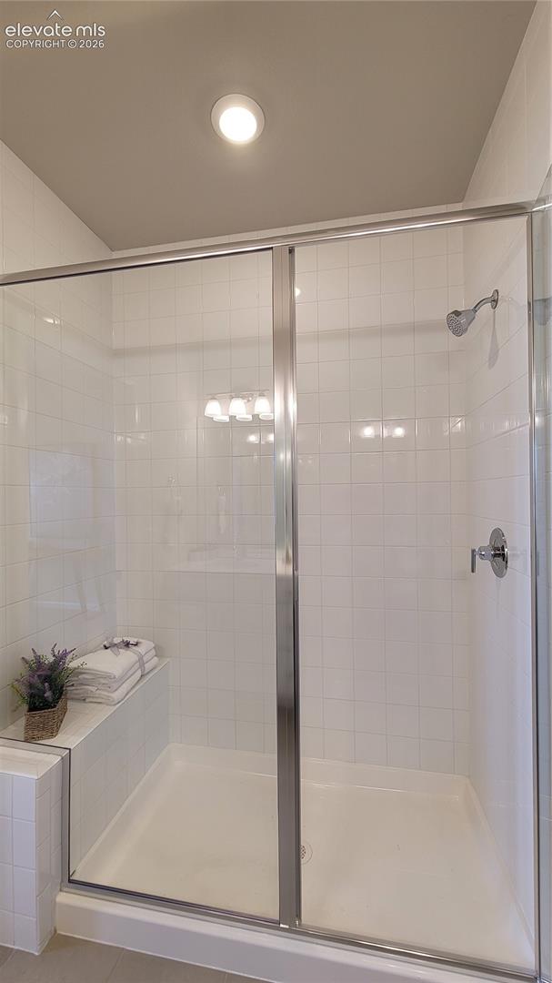 Primary 3/4 Bathroom with double vanities, shower with bench and tile surrounds, cabinet/drawer pulls, quartz countertop, and linen closet! 