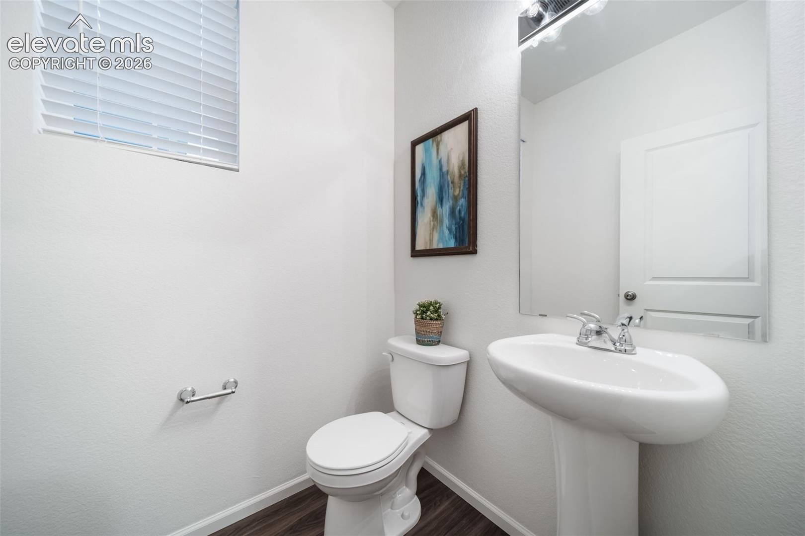 Pedestal sink with chrome fixtures, wood-finish flooring, and white walls
*photos of a model home*