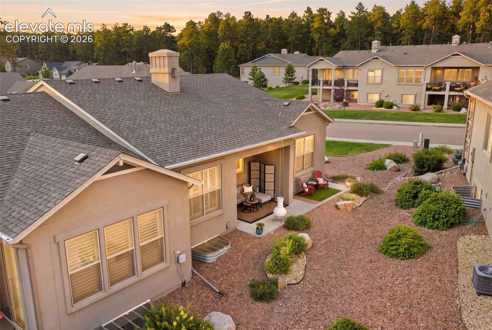 Rear exterior view featuring the expanded patio outdoor living space, and rock landscaping.