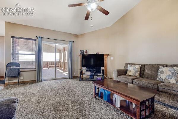 Spacious room featuring vaulted ceilings, ceiling fan with integrated lighting, and neutral wall tones