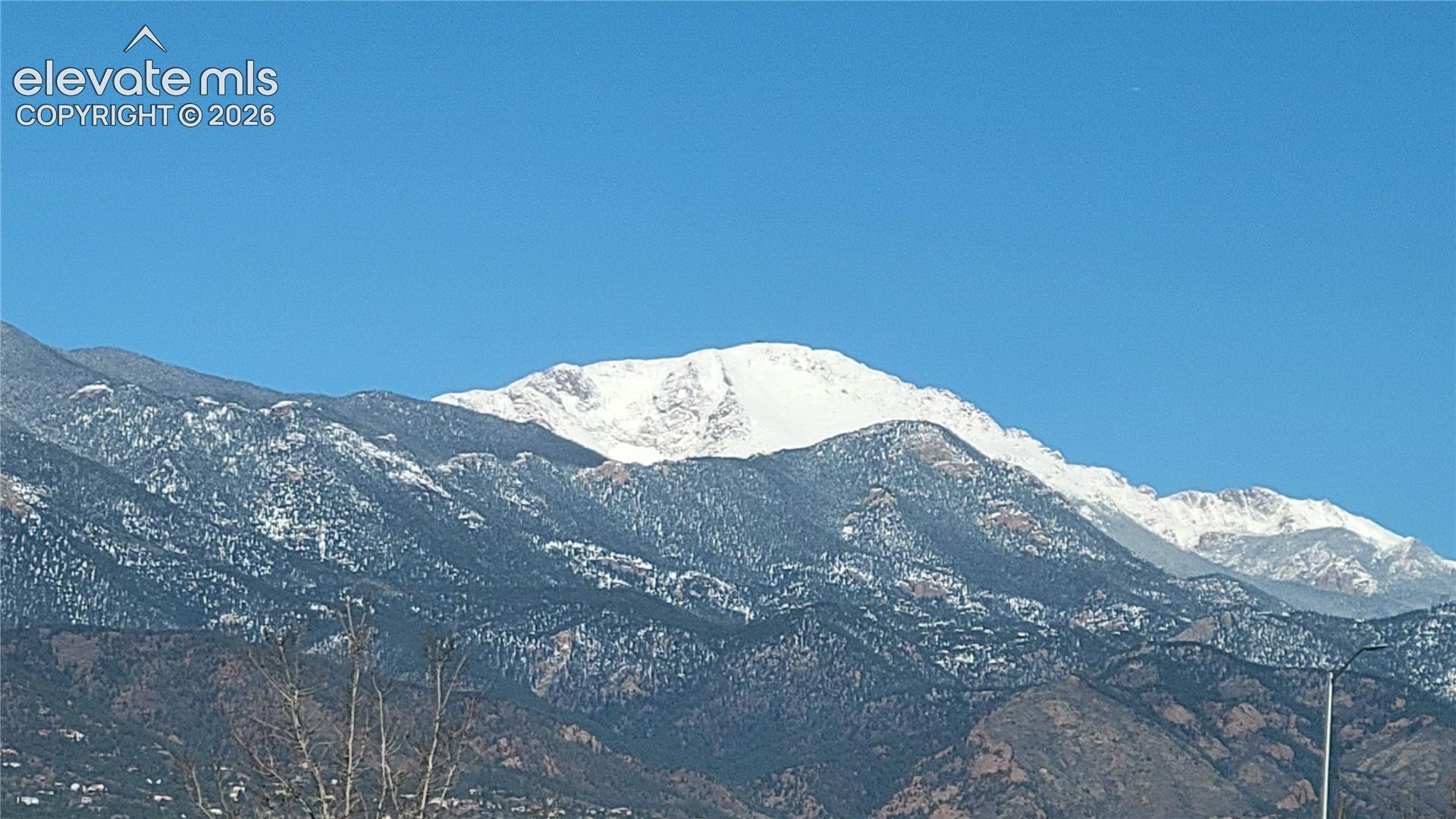 View of a snow-capped Pikes Peak under a clear blue sky from the deck