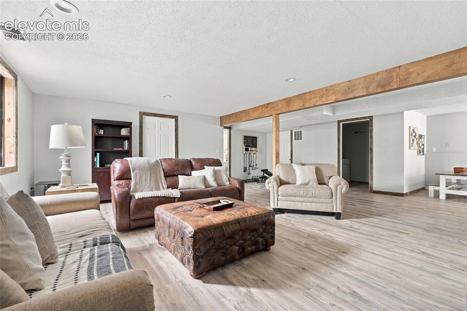 Recessed lighting, wood-finish flooring, wood-framed window, exposed wood beam, built-in shelving