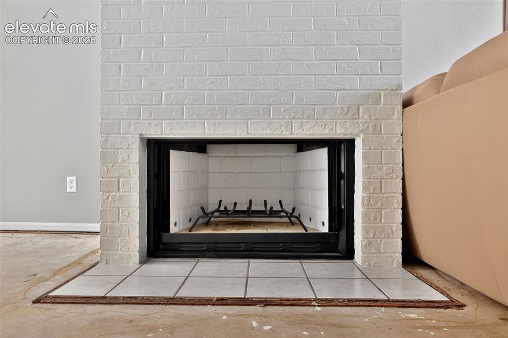 White brick fireplace with a black metal firebox and white tile hearth