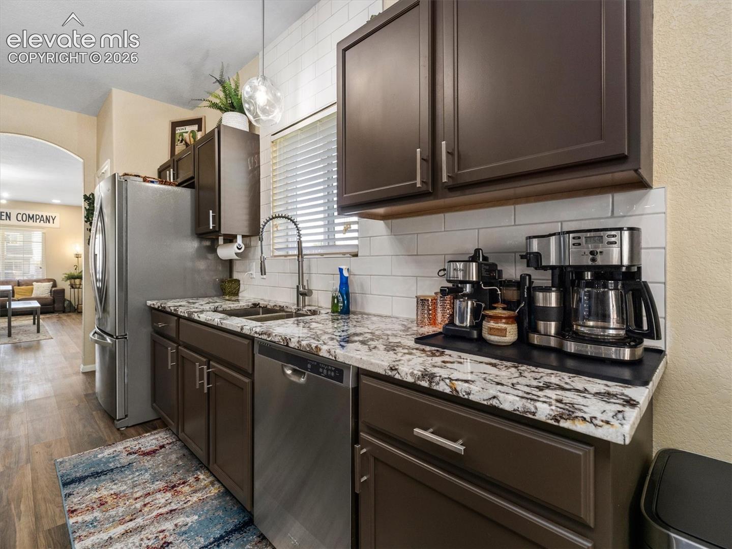 Kitchen featuring LVP flooring, dark cabinetry, and light-toned countertops with an integrated sink