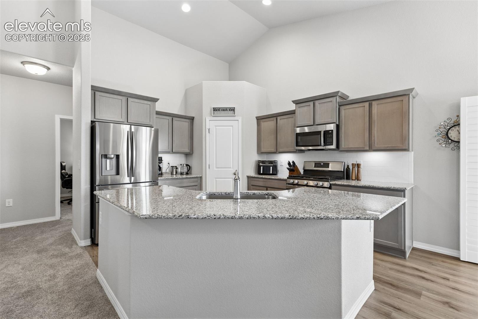 The beautiful, open kitchen has granite counter tops, bar seating, a full stainless appliance package and a walk-in pantry.