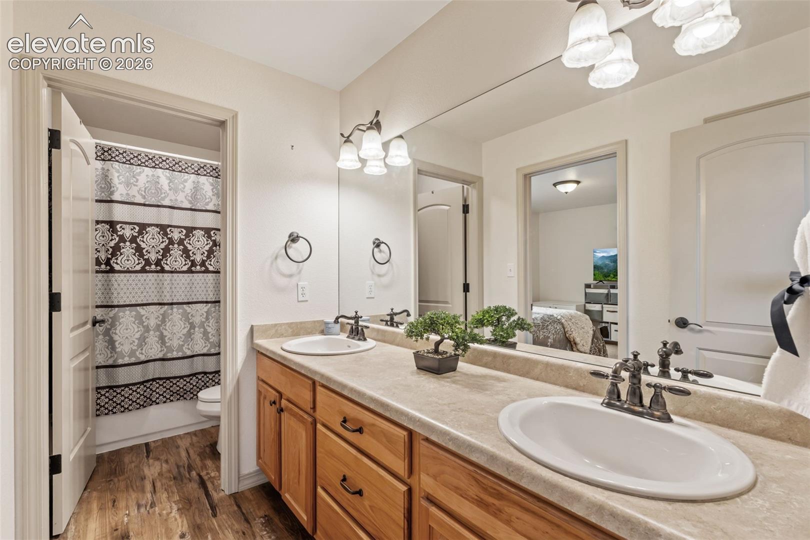 Dual vanity with wood cabinetry and light-toned countertops