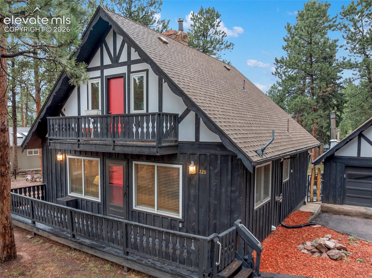 Distinctive Tudor-style exterior with black vertical siding and white trim