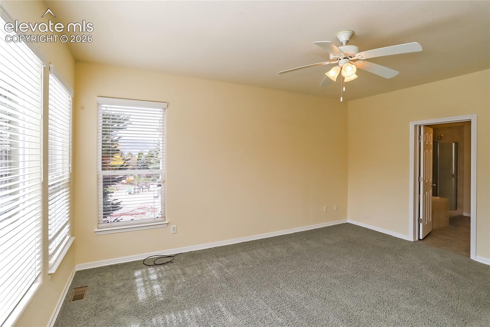 Primary bedroom on the main level features an en-suite bathroom and a walk-in closet.