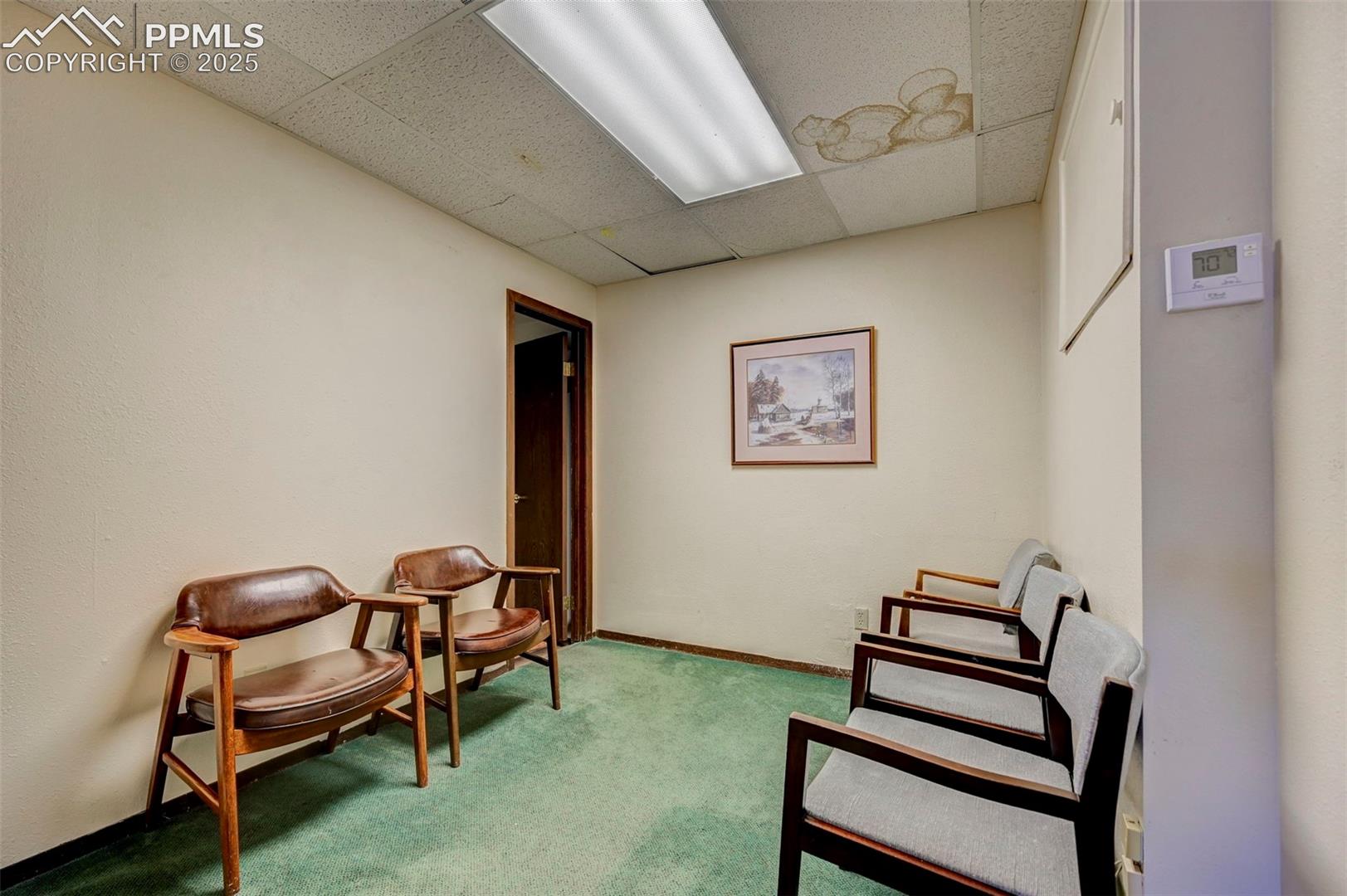 Sitting room featuring a drop ceiling and carpet flooring