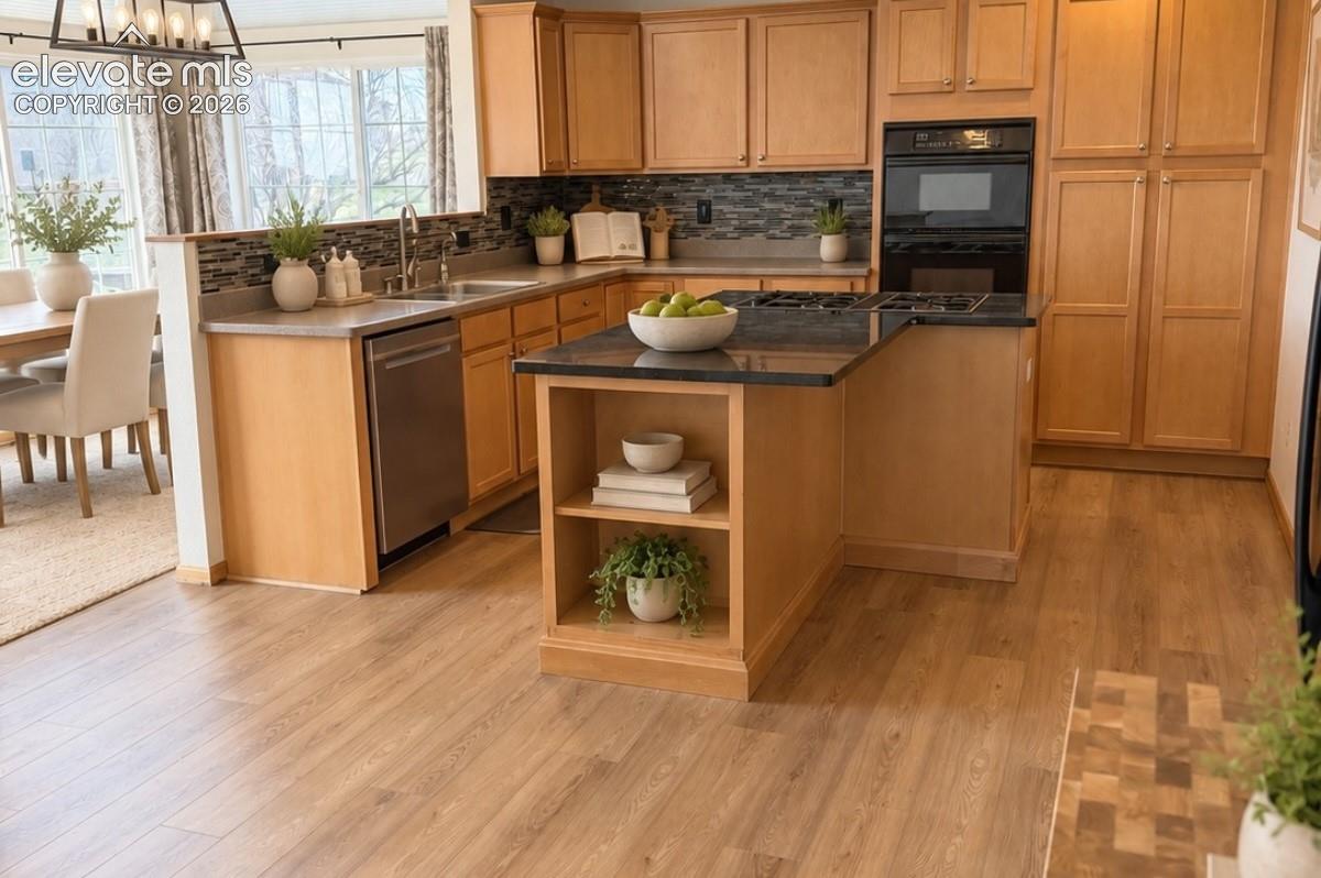 Kitchen featuring wood-finish flooring, light wood cabinetry, a built-in oven, stainless steel dishwasher, and a center island with open shelving, virtual staging