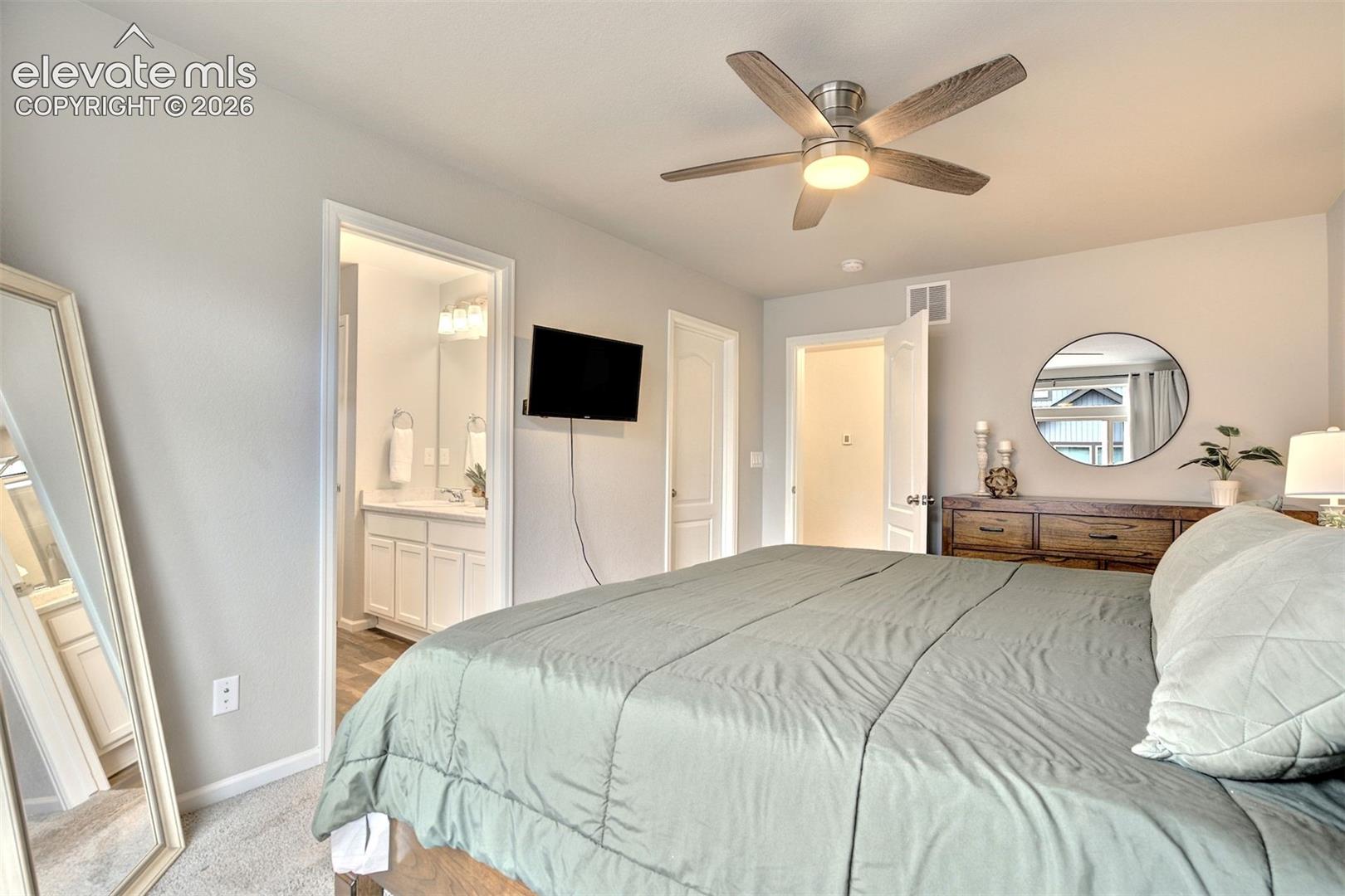 Neutral wall paint, ceiling fan with light fixture, and plush carpeting