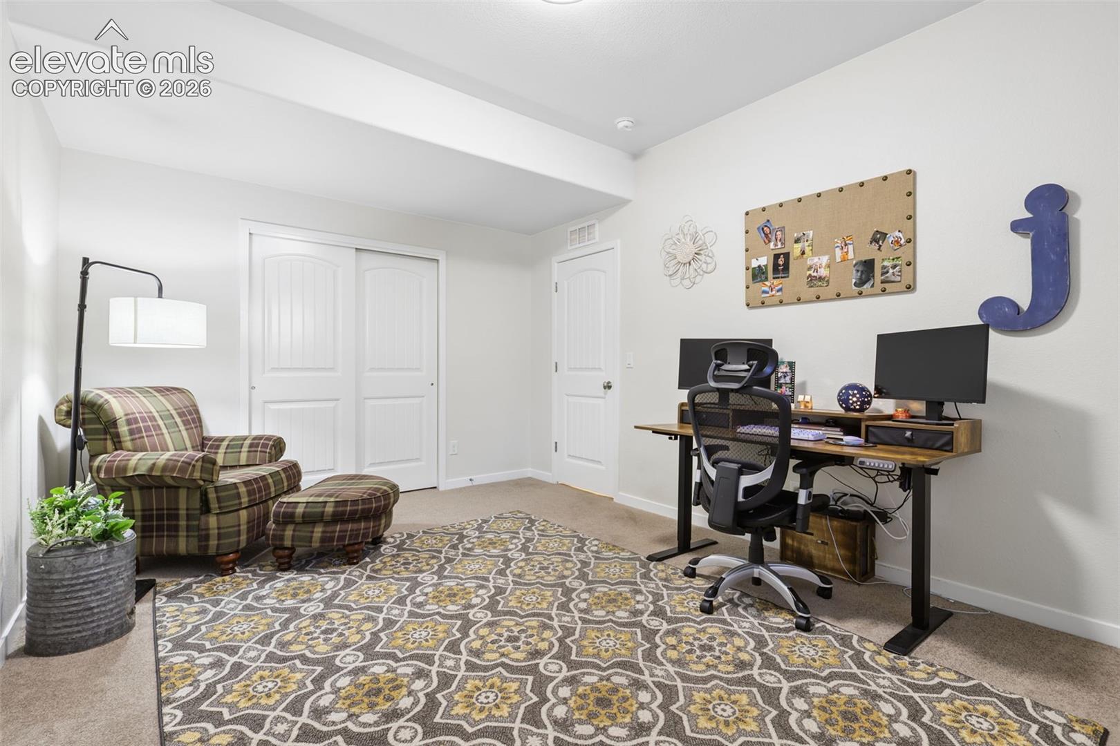 Carpet flooring with light-colored walls, white painted trim, and a white interior door