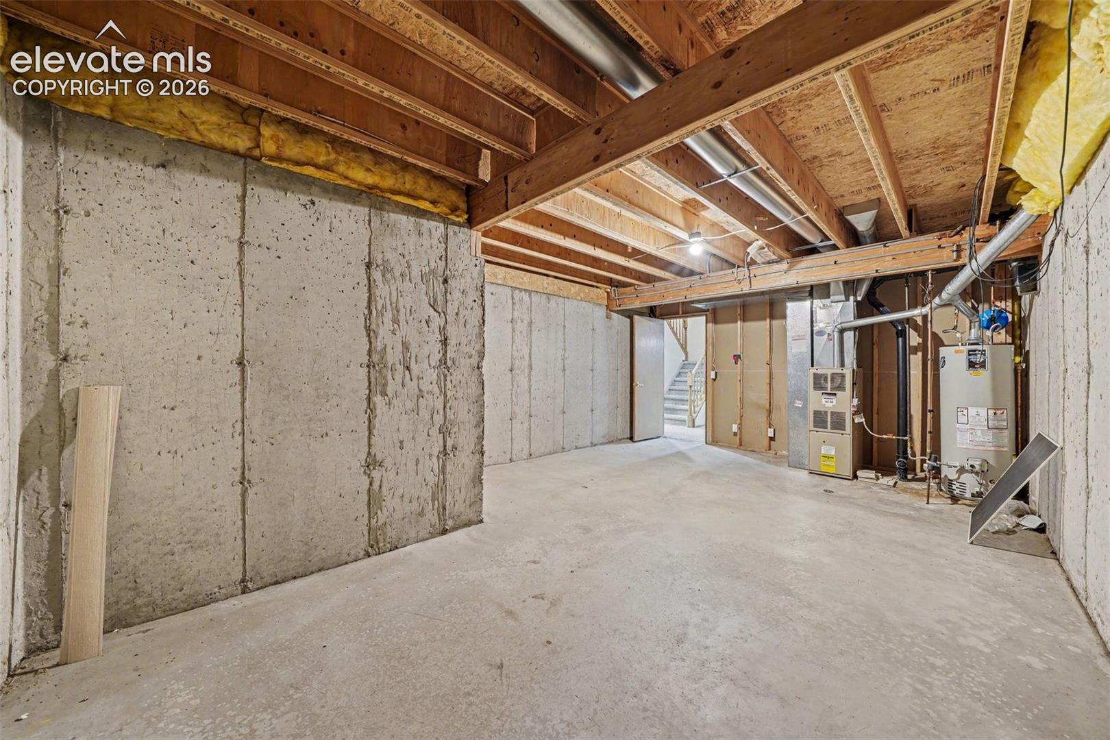 Unfinished concrete basement with exposed ceiling joists
