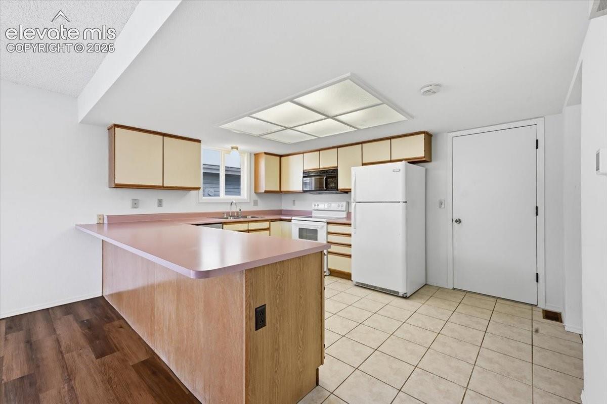 Eat-in kitchen with ample cabinetry and a full appliance package at , Colorado Springs, CO.