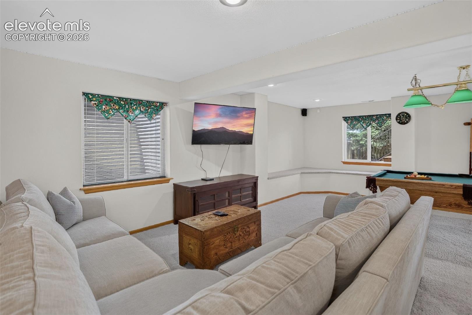 Spacious recreational room featuring light-colored carpeting and recessed lighting