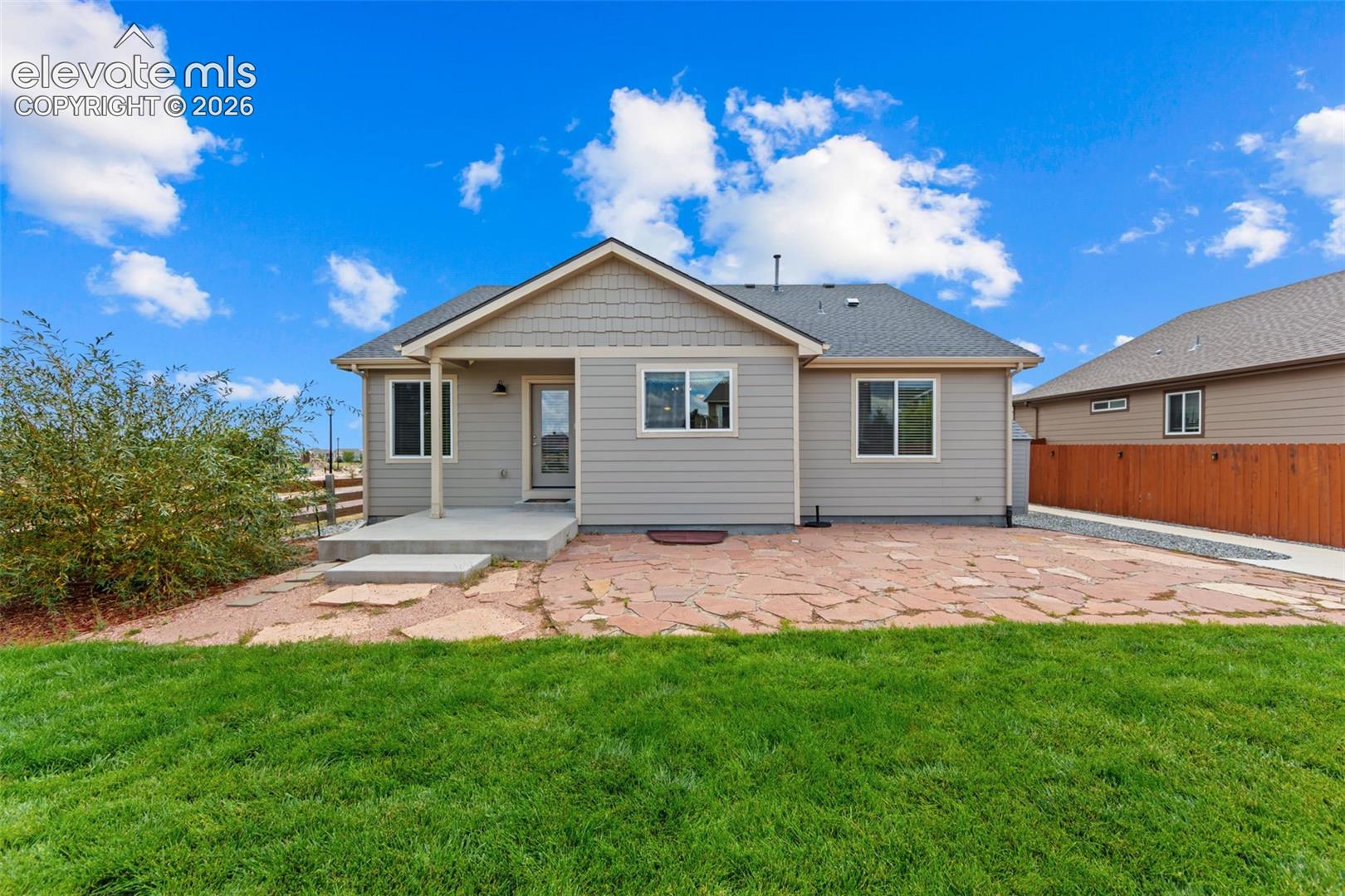 Modern ranch-style home featuring a freshly finished exterior with light-colored siding, a pitched roof, and covered front porch