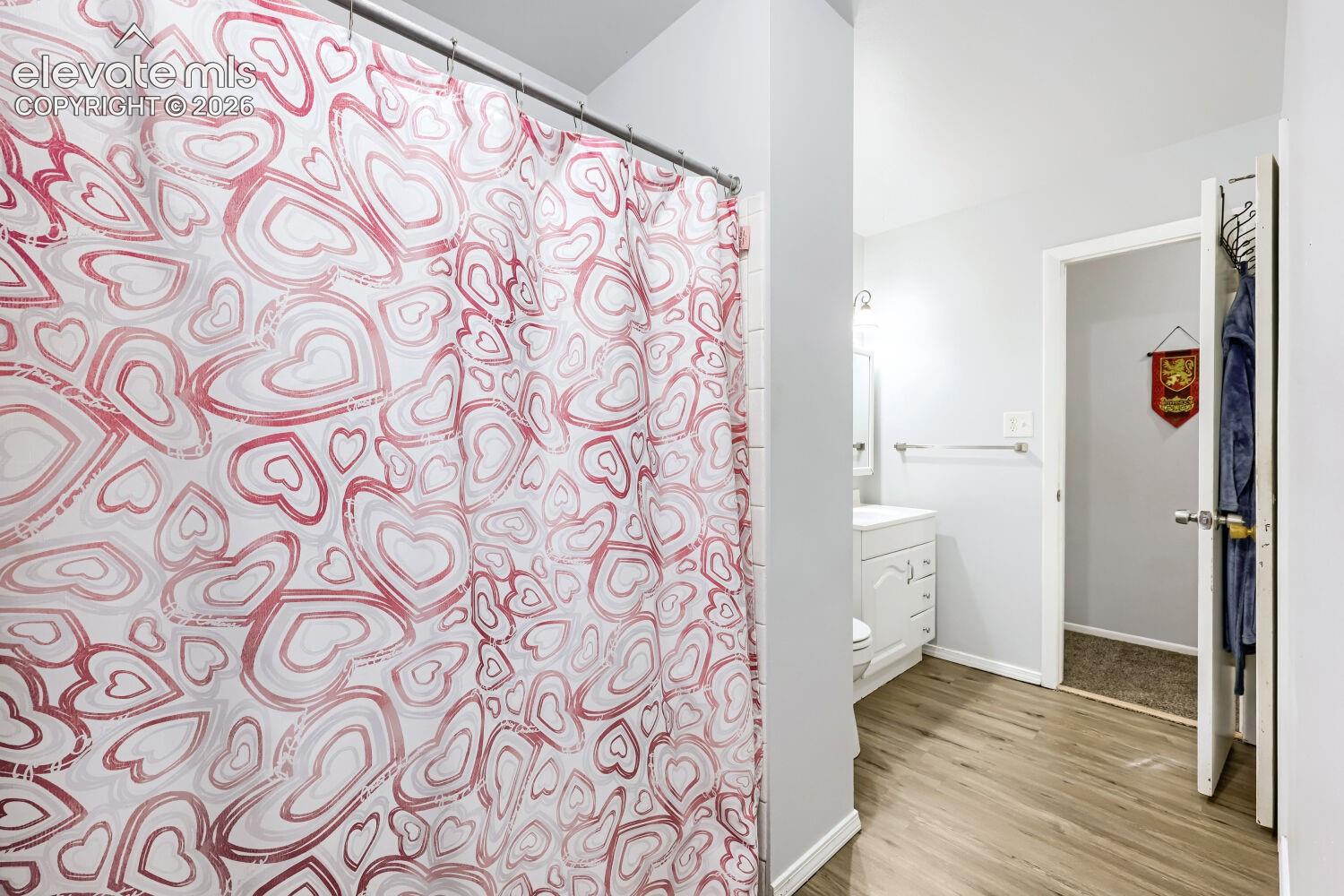 Wood-finish flooring with light wall tones and white baseboards
