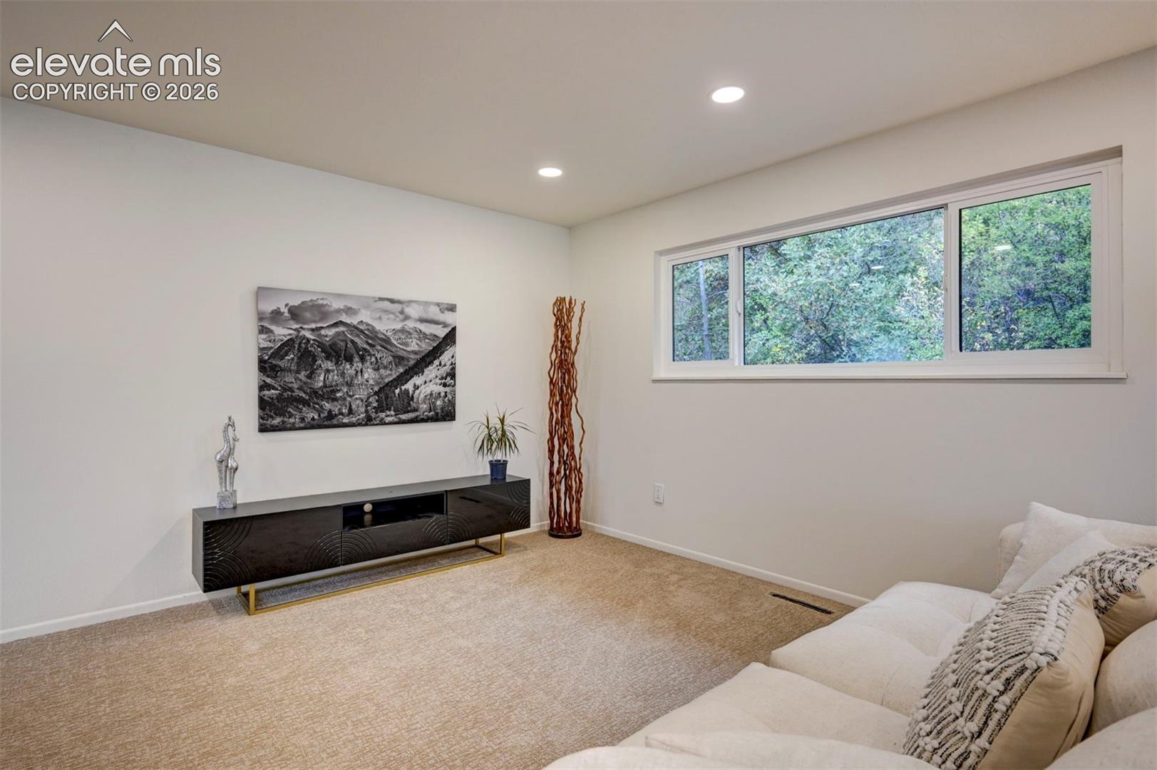 Interior space featuring neutral wall tones, recessed lighting, and a wide sliding window