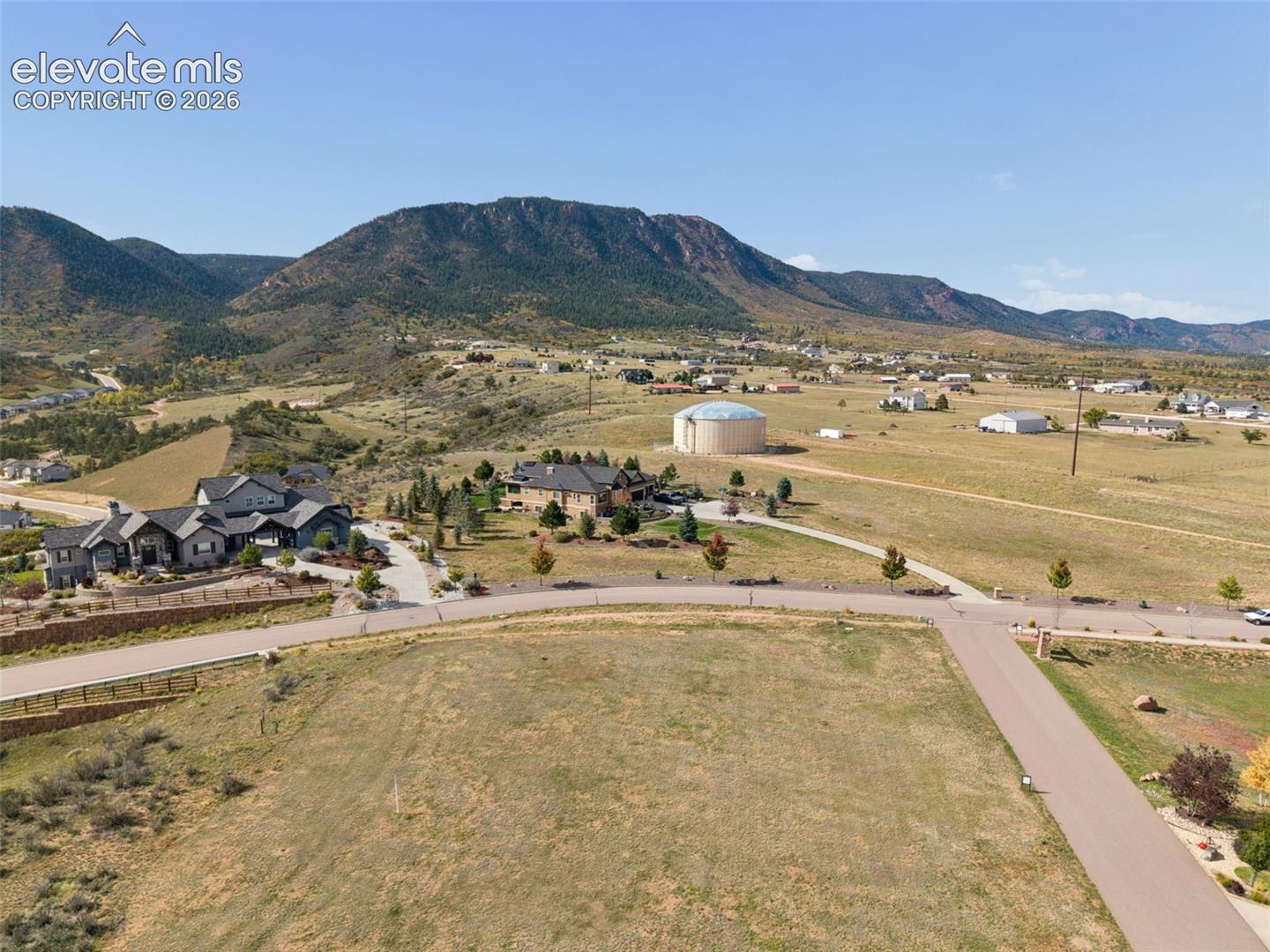 Expansive land parcel featuring paved street access, native landscaping, and prominent mountain backdrops