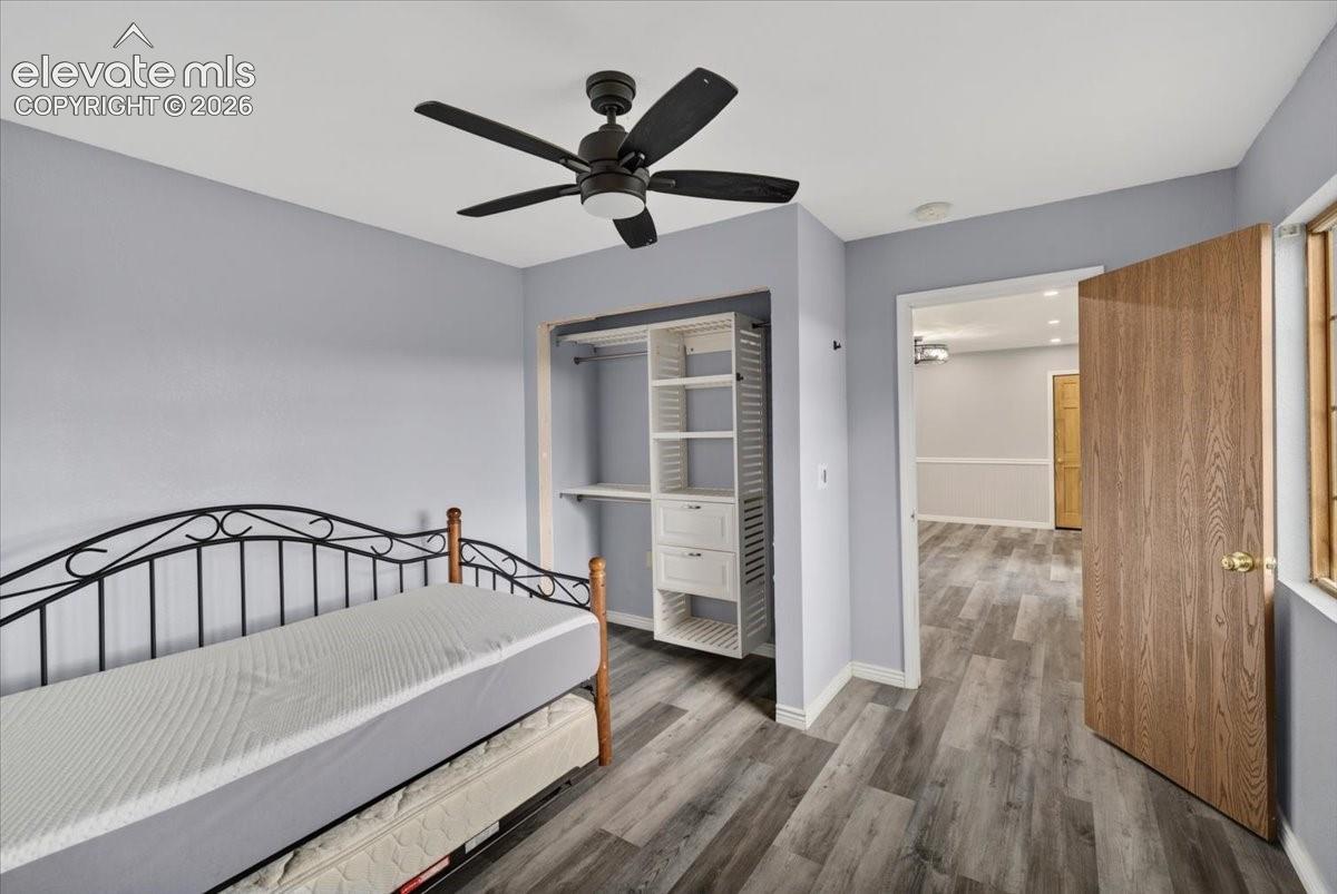 Wood-finish flooring, ceiling fan with integrated lighting, and custom built-in closet organization system