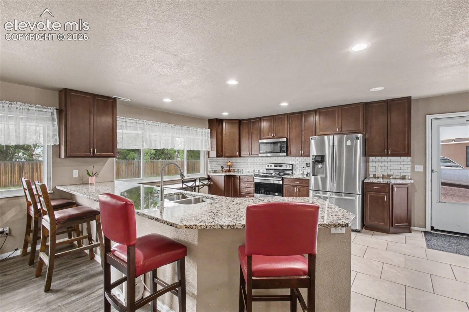 Center granite countertop island with seating, perfect for casual meals, morning coffee, or gathering with family and friends.