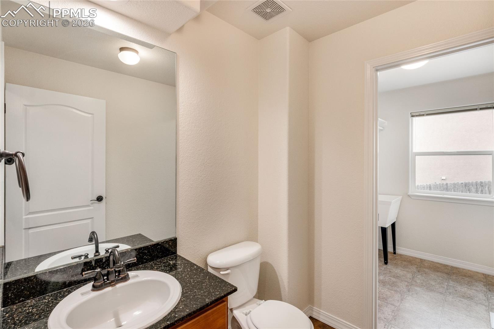 Main floor half bathroom with attached laundry room.