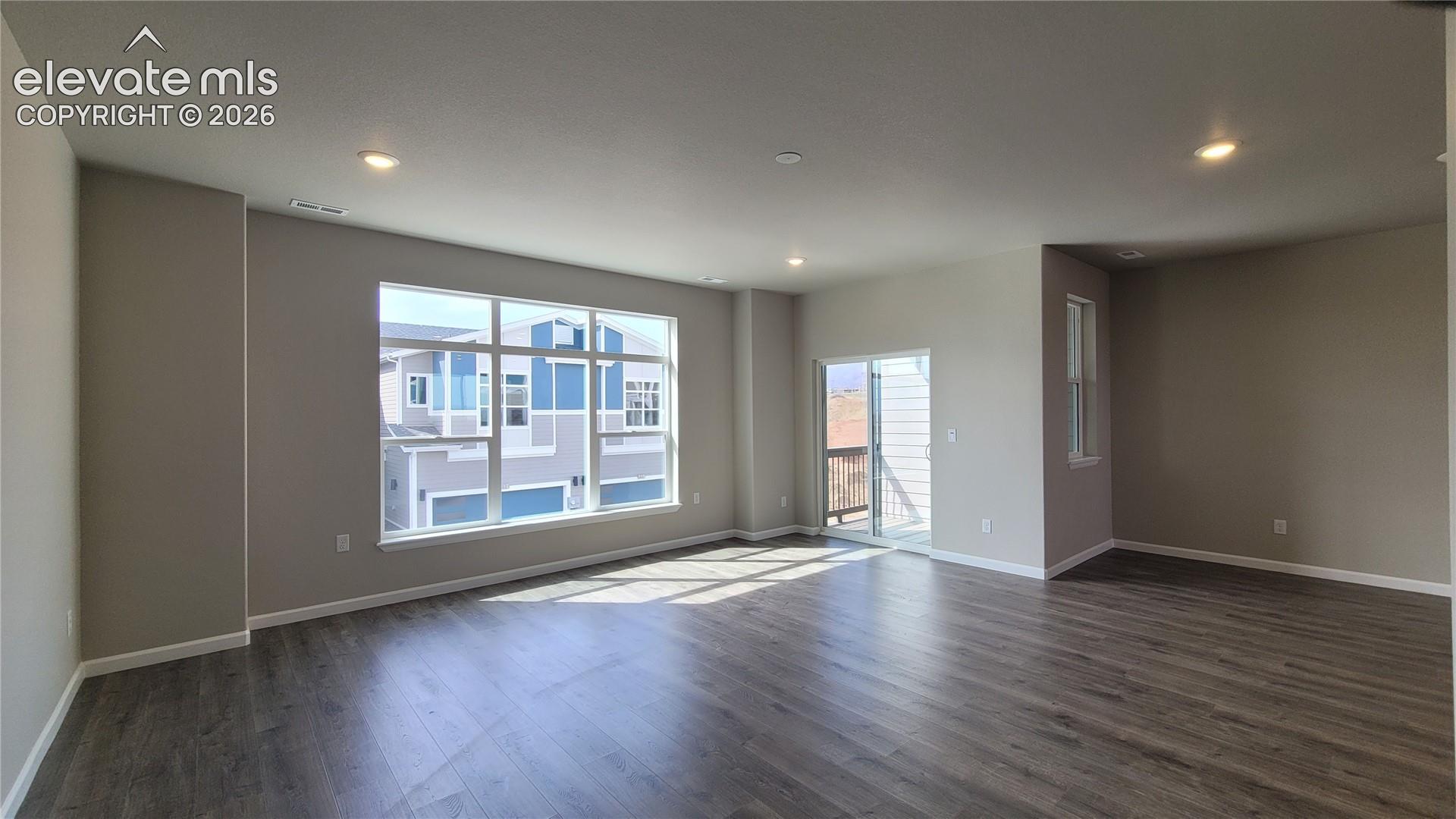 Living room with LVP flooring, LED lighting, Walk-Out to Composite Deck, and an abundance of natural light through the large window!