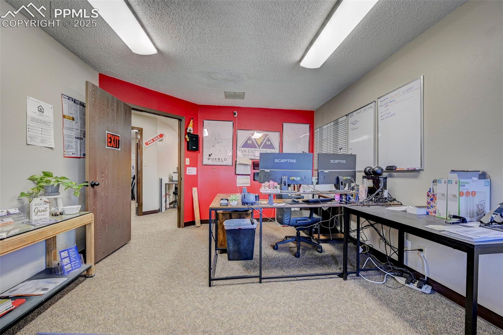 Office space featuring a textured ceiling and carpet