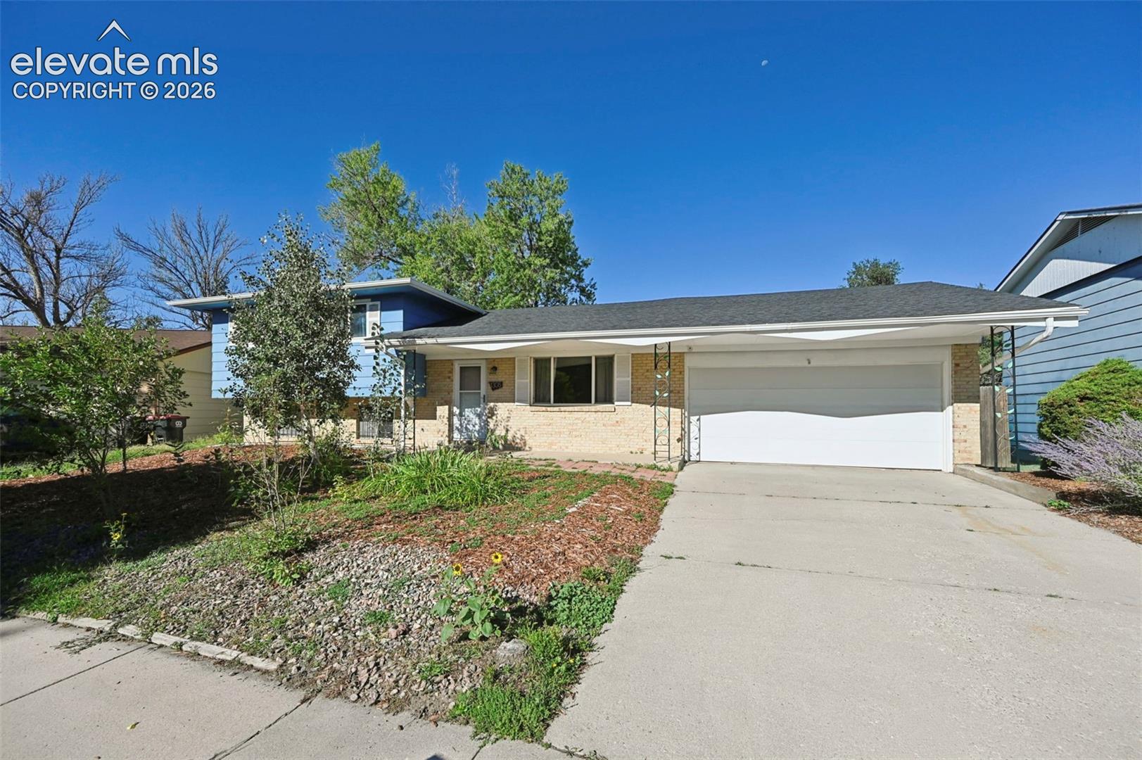 siding facade, an attached garage, and a concrete driveway