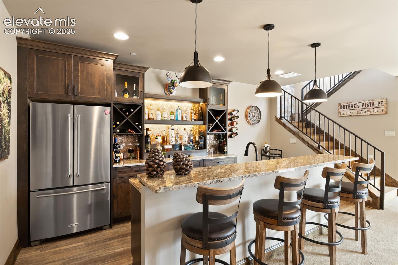 The unofficial favorite room in the house. Full wet bar with stainless fridge, granite island seating, custom wine storage, and walk-out access to the patio.