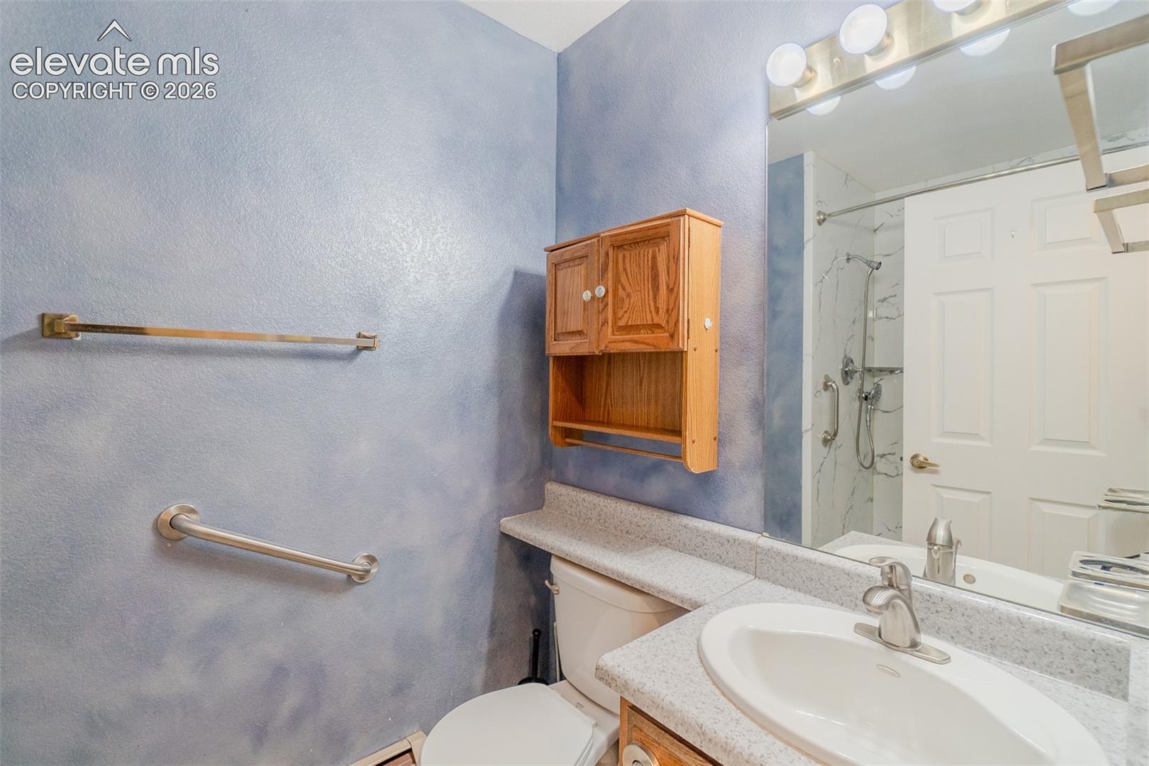 Main level bathroom with Vanity, safety bars, stand up shower
