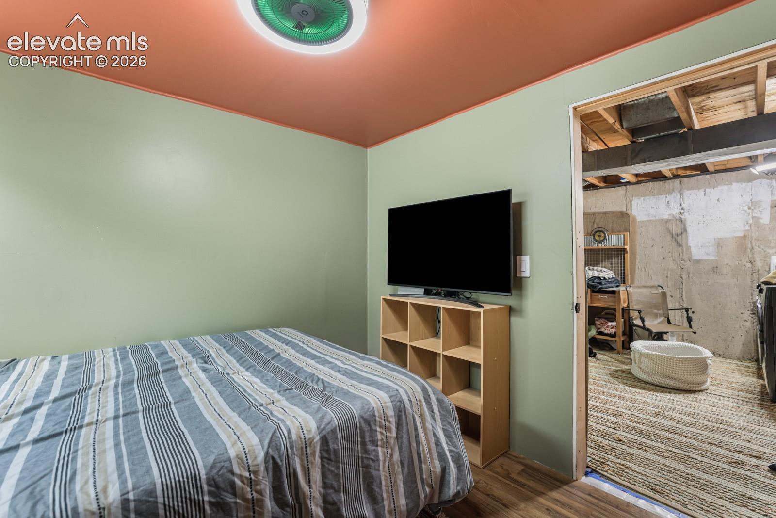 Interior room featuring wood-finish flooring, light green walls, and a warm-toned ceiling