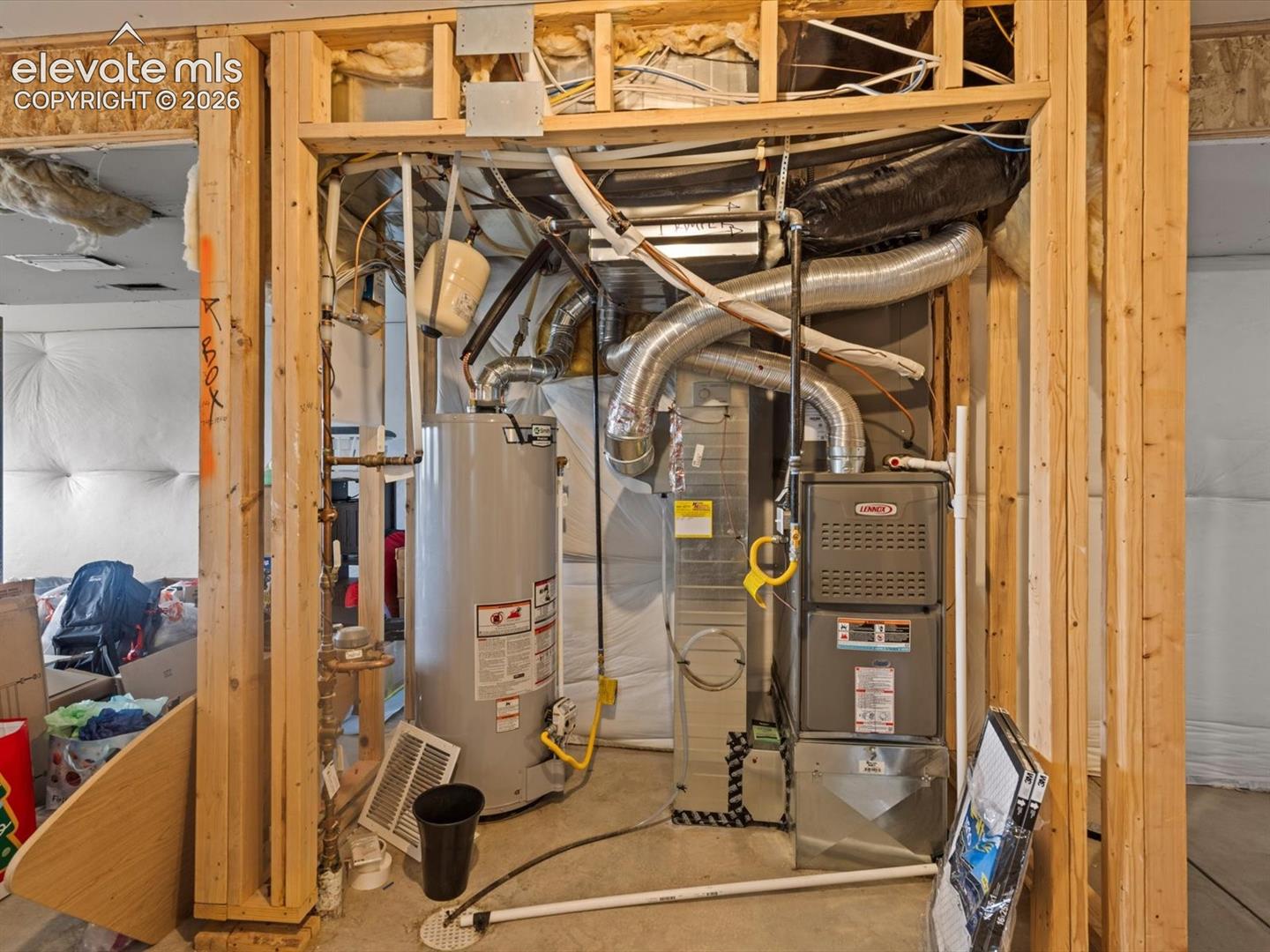 Mechanical room featuring a water heater, furnace unit, and extensive ductwork