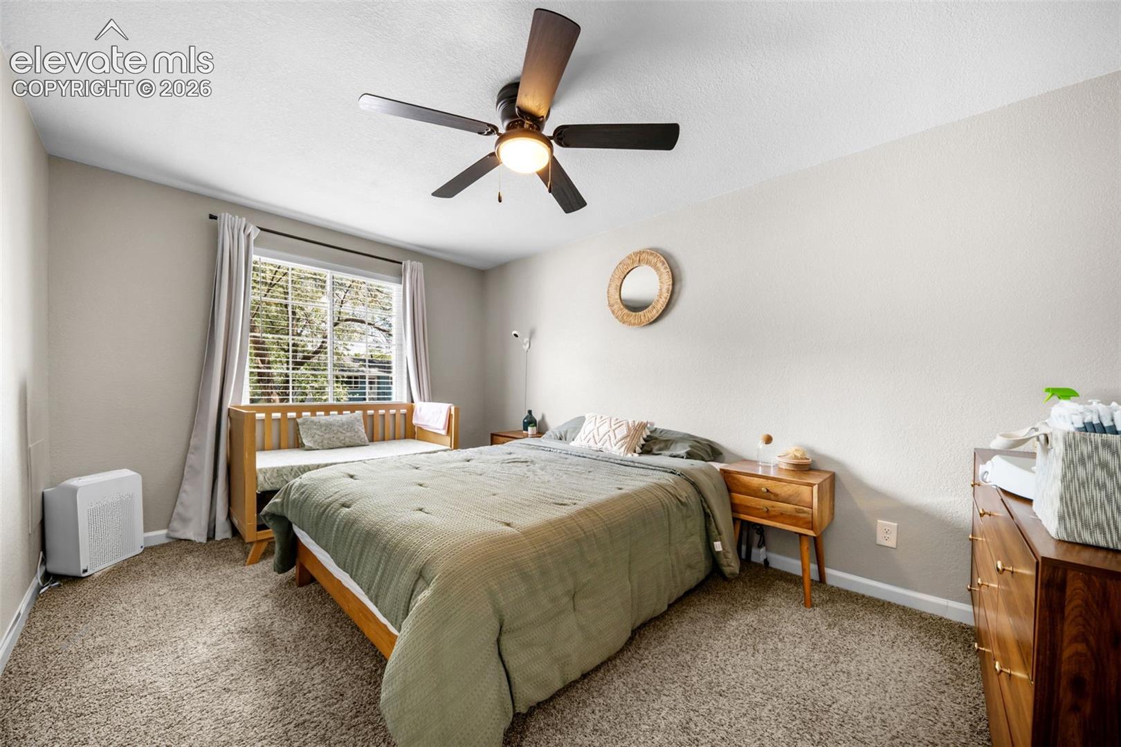 Window with blinds, ceiling fan with integrated lighting, textured wall finish, and carpeted flooring